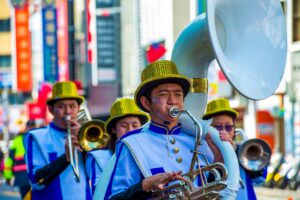 Vibrant marching band playing in a colorful street parade in Taiwan, featuring wind instruments.